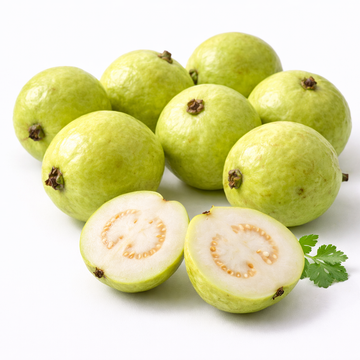 Green guava fruits with a halved guava on a white background