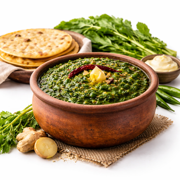Bowl of green curry with naan bread and vegetables on a white background